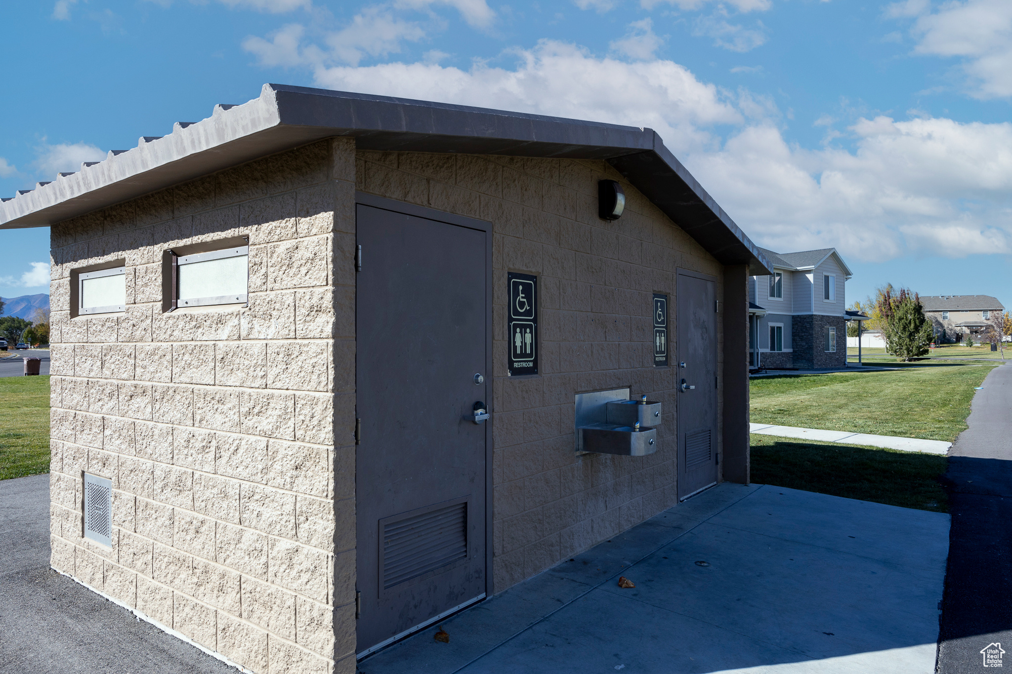 View of home's exterior with concrete block siding and a lawn