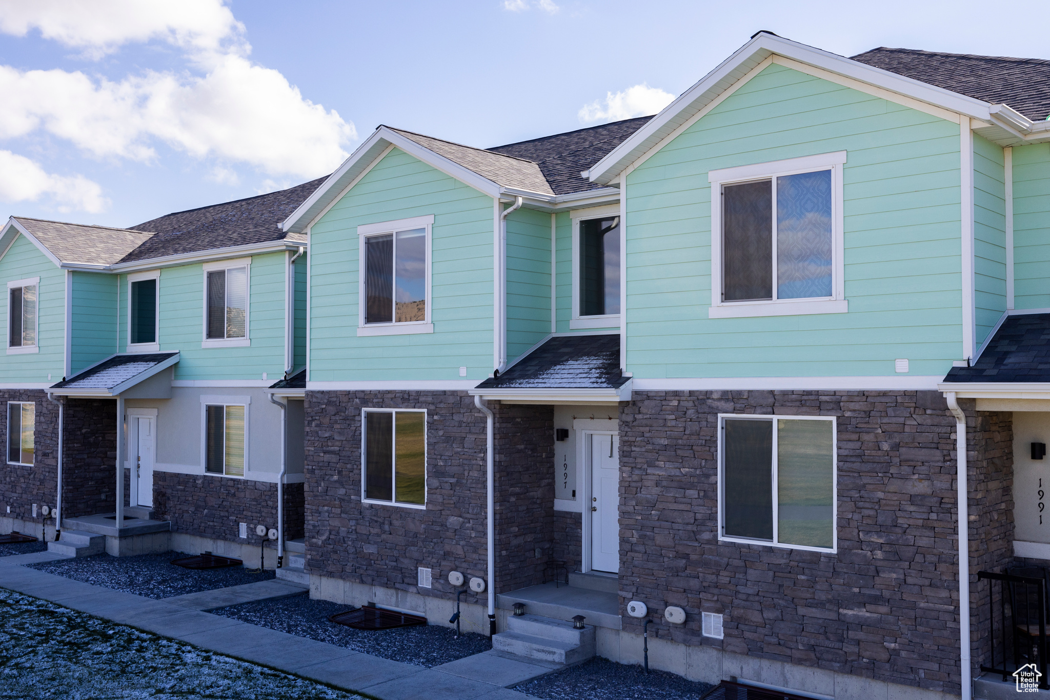 View of front of house with stone siding and roof with shingles