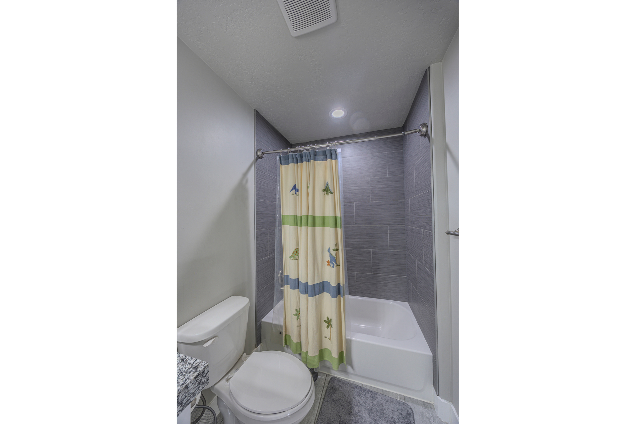 Bathroom featuring shower / bath combination with curtain, toilet, and visible vents