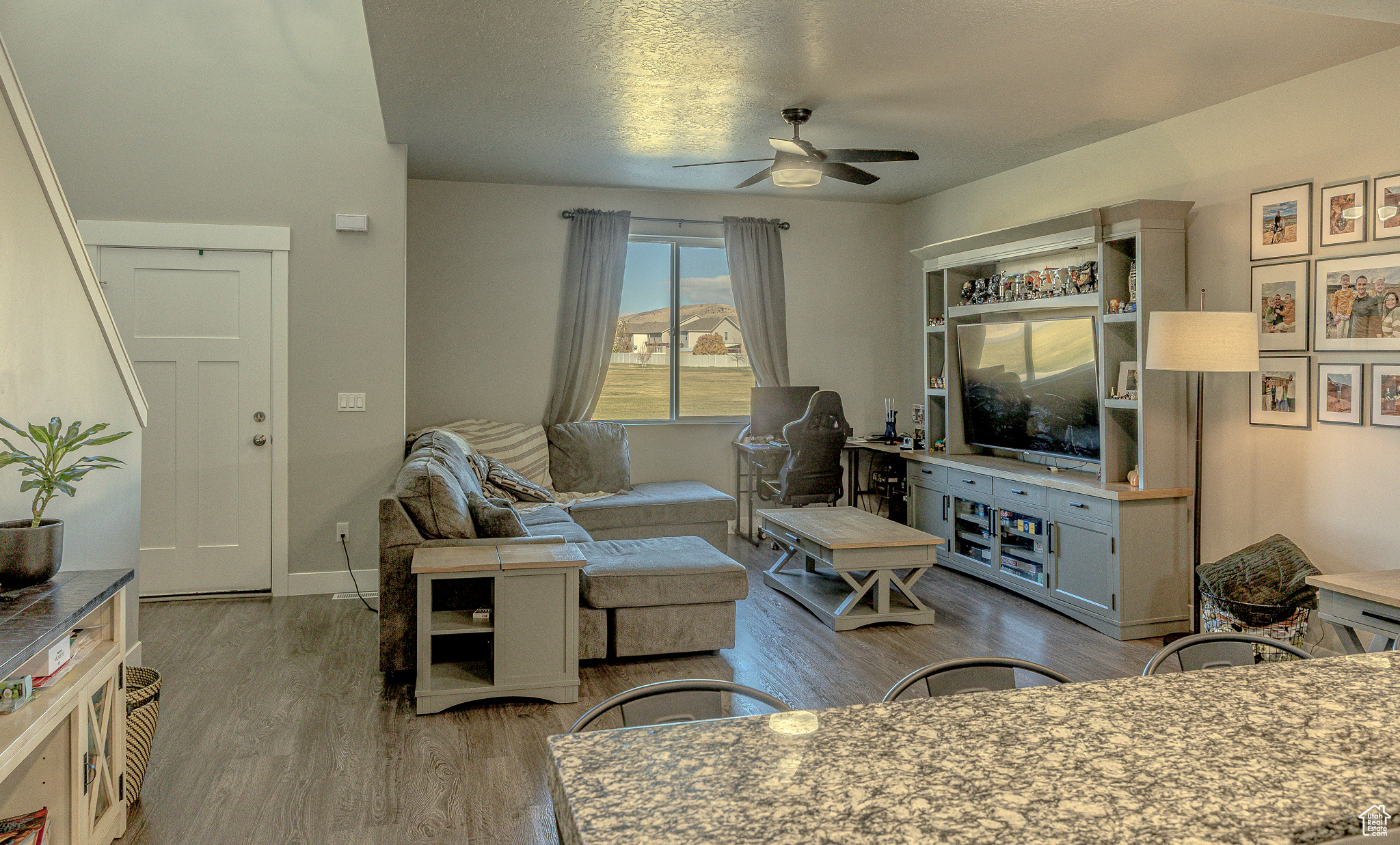 Living room featuring baseboards, wood finished floors, and a ceiling fan