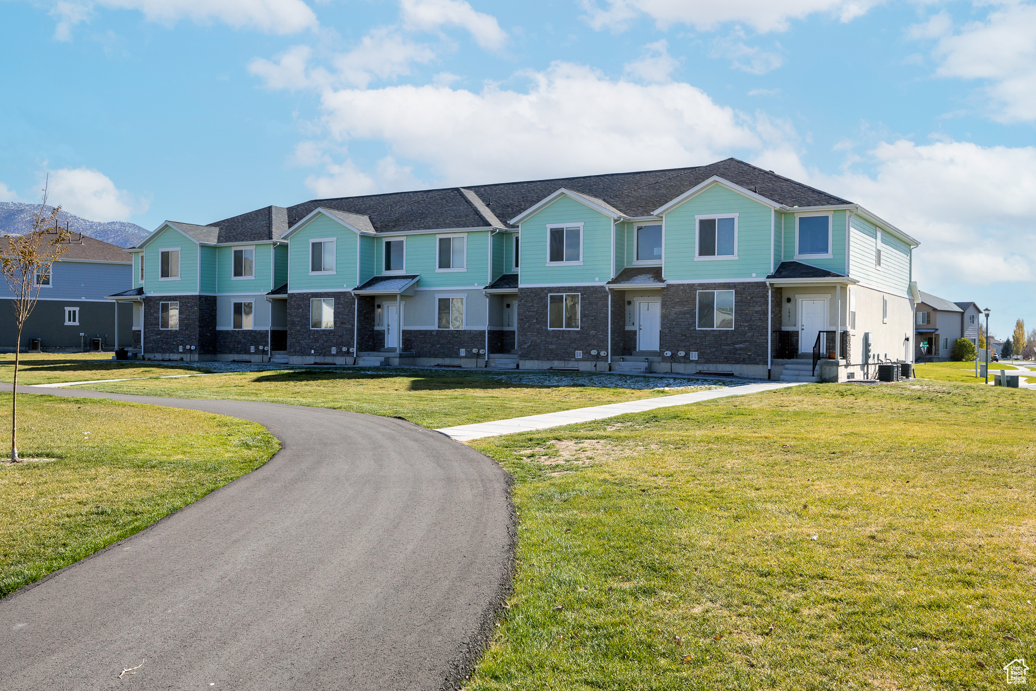 View of front of home featuring a front yard, central air condition unit, brick siding, and a residential view