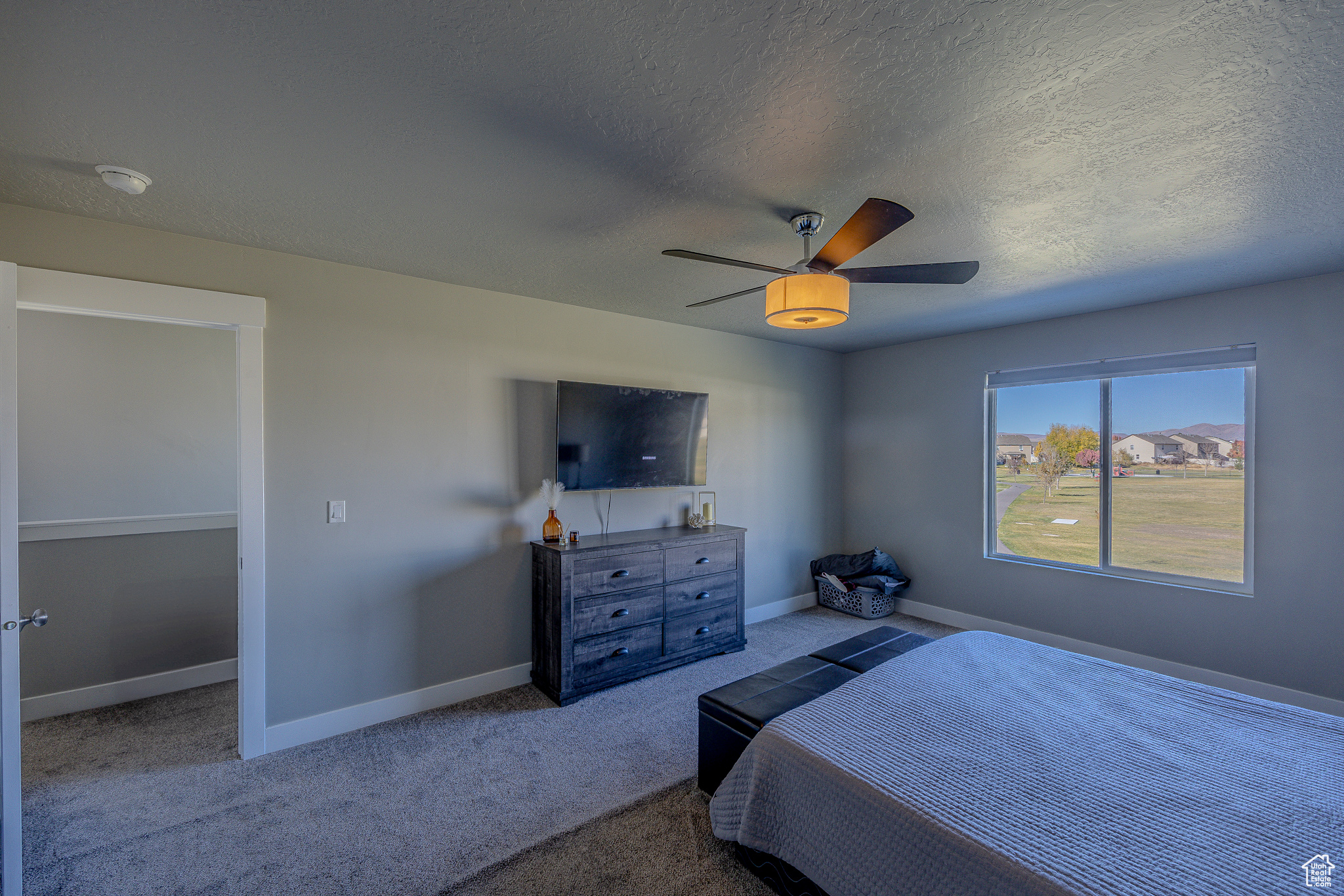 Bedroom featuring carpet flooring, ceiling fan, a textured ceiling, and baseboards