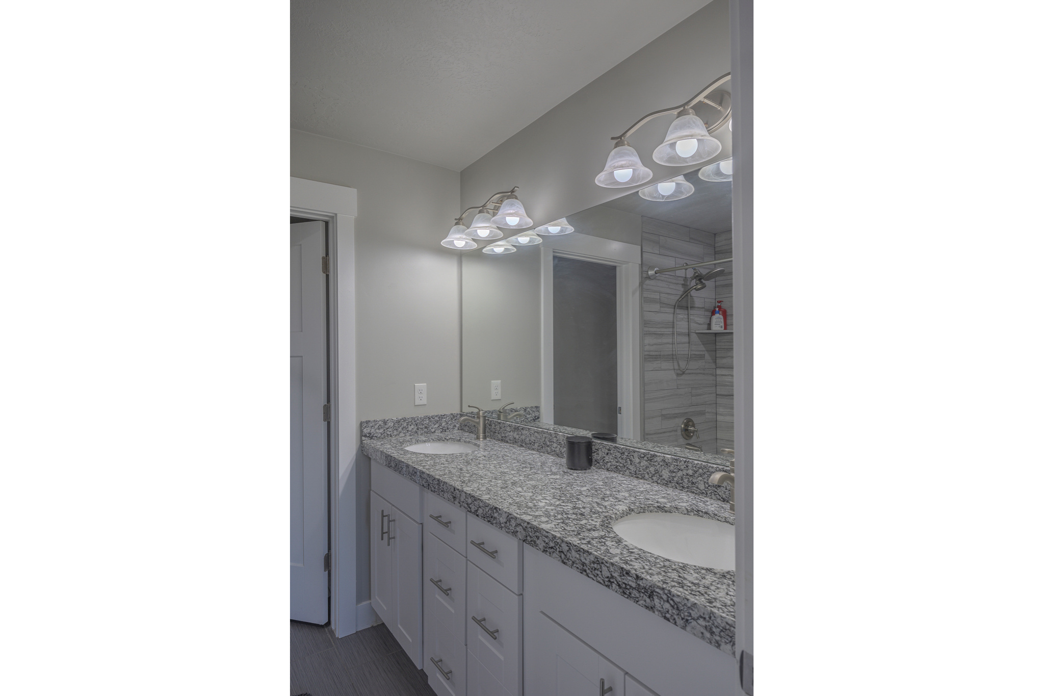 Bathroom with double vanity, a tile shower, and a sink