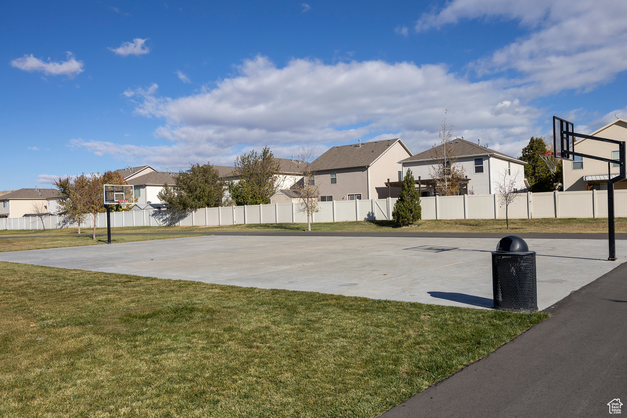 View of sport court featuring a residential view, community basketball court, a lawn, and fence