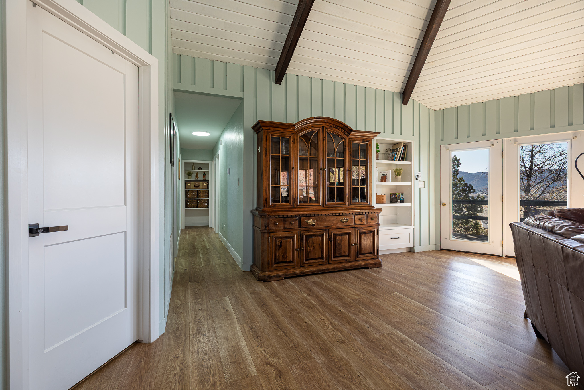 Dining space with wood finished floors and vaulted ceiling with beams