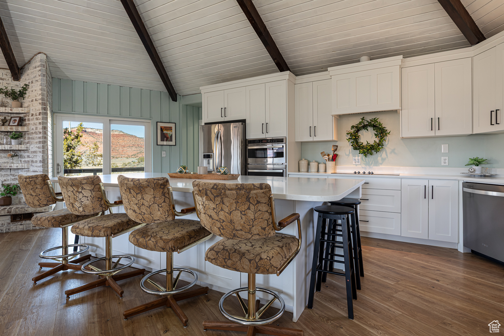 Kitchen featuring dark wood finished floors, light countertops, white cabinetry, and appliances with stainless steel finishes