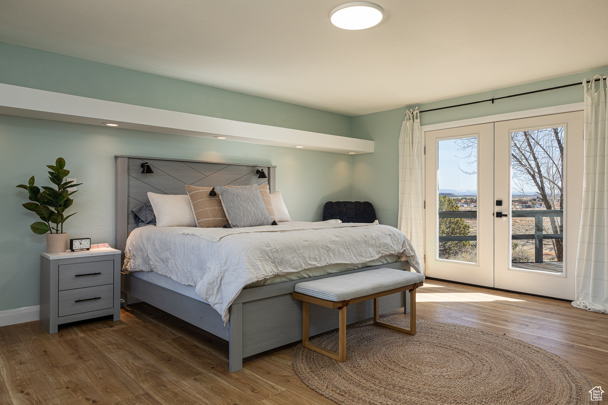 Bedroom featuring french doors, wood finished floors, baseboards, and access to exterior