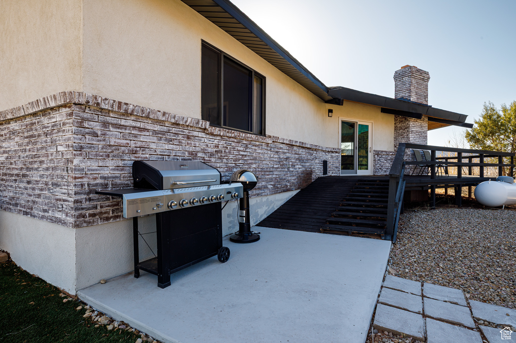 View of patio featuring area for grilling and a deck