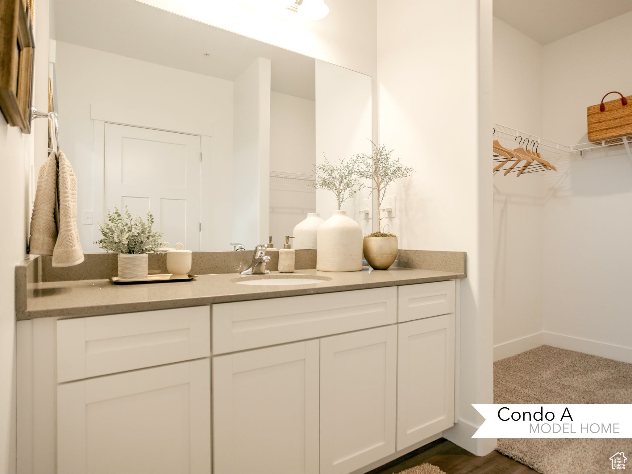 Bathroom featuring a spacious closet, vanity, and baseboards