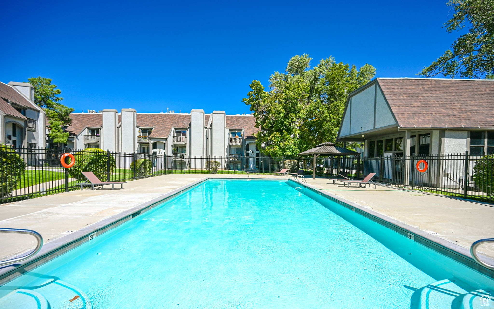 Community pool featuring a gazebo, a residential view, a patio, and fence