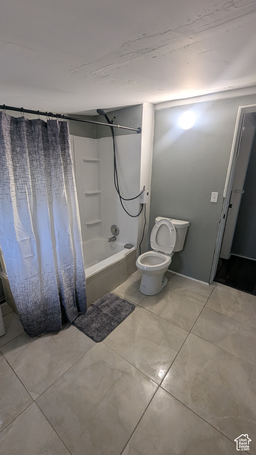 Full bath featuring shower / bathtub combination with curtain and toilet
