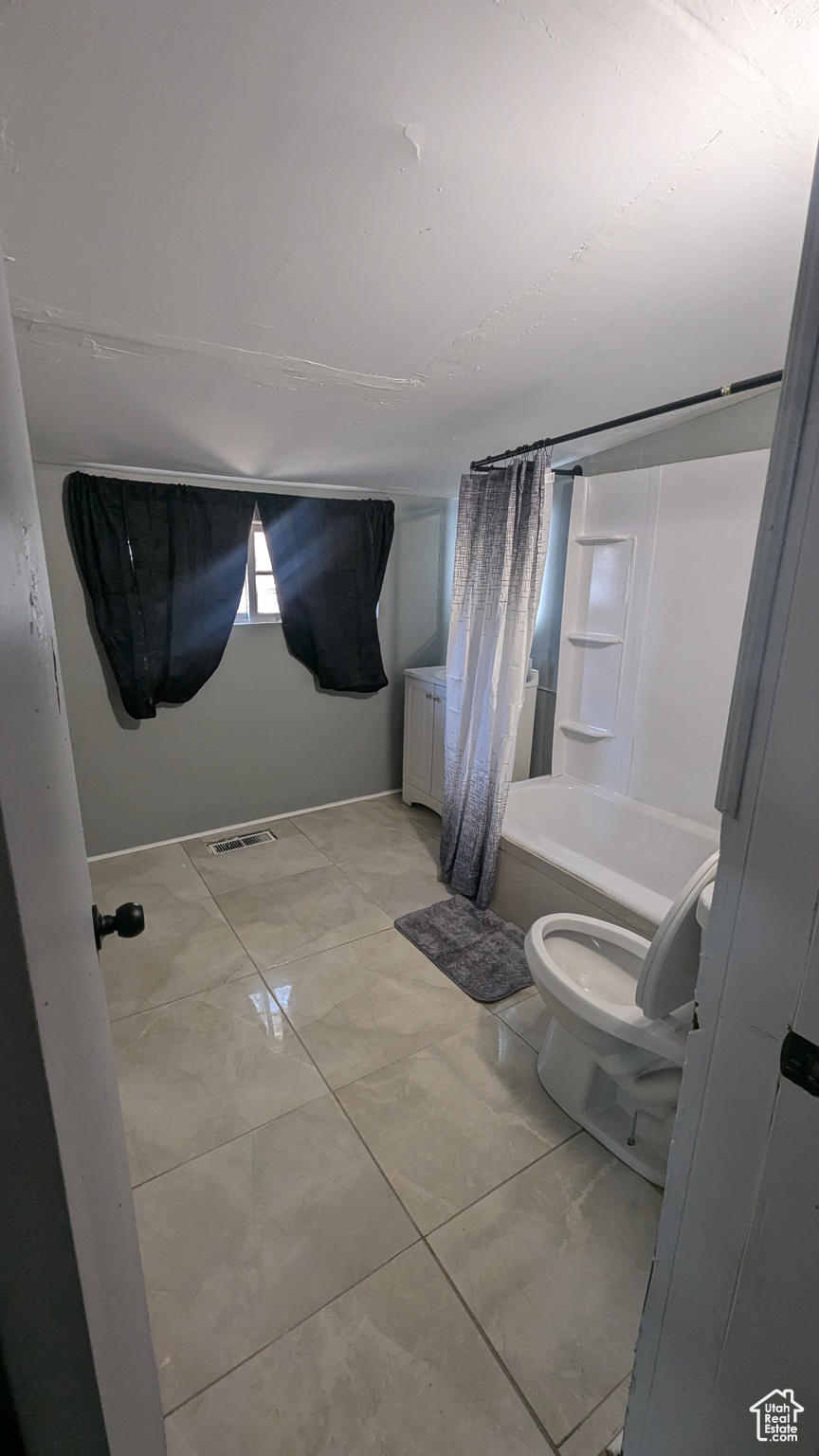 Bathroom featuring shower / bathtub combination with curtain, toilet, and visible vents