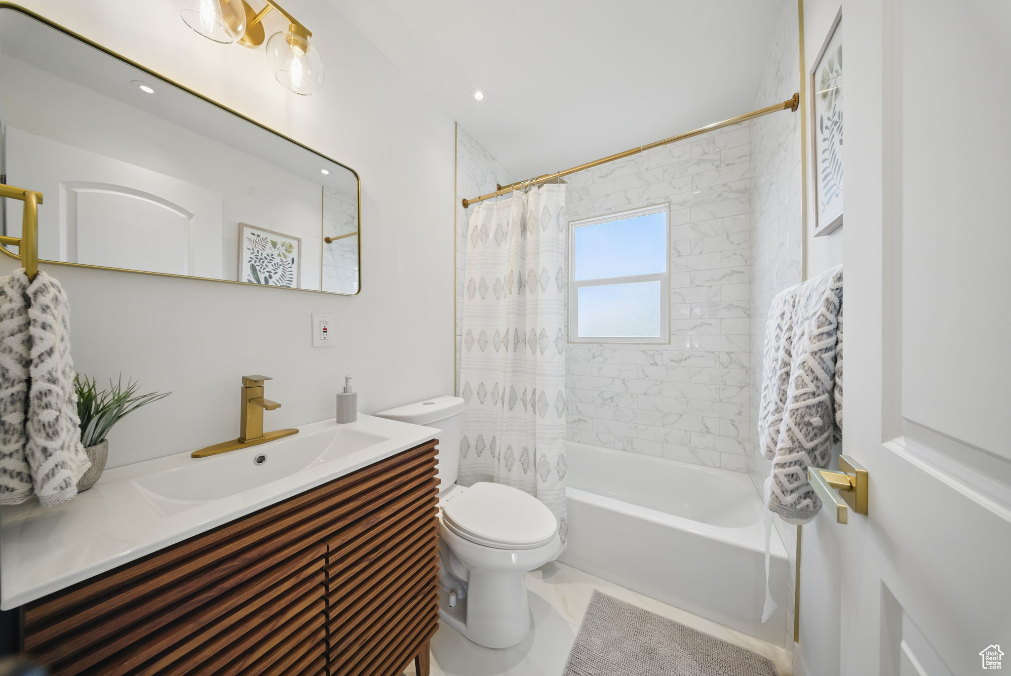 Full bath with vanity, toilet, and shower / bath combo with shower curtain