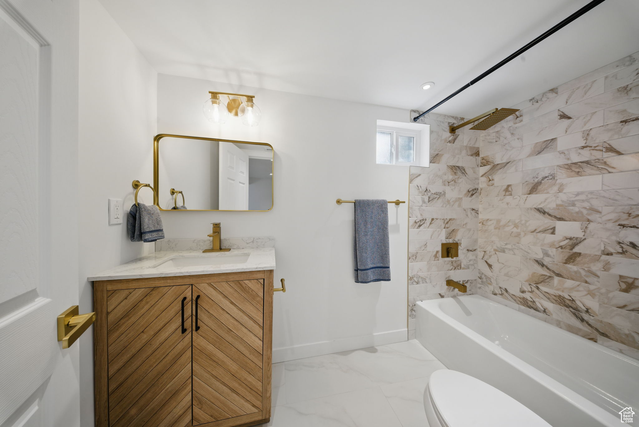 Bathroom featuring vanity, baseboards, shower / bathing tub combination, toilet, and marble finish floor