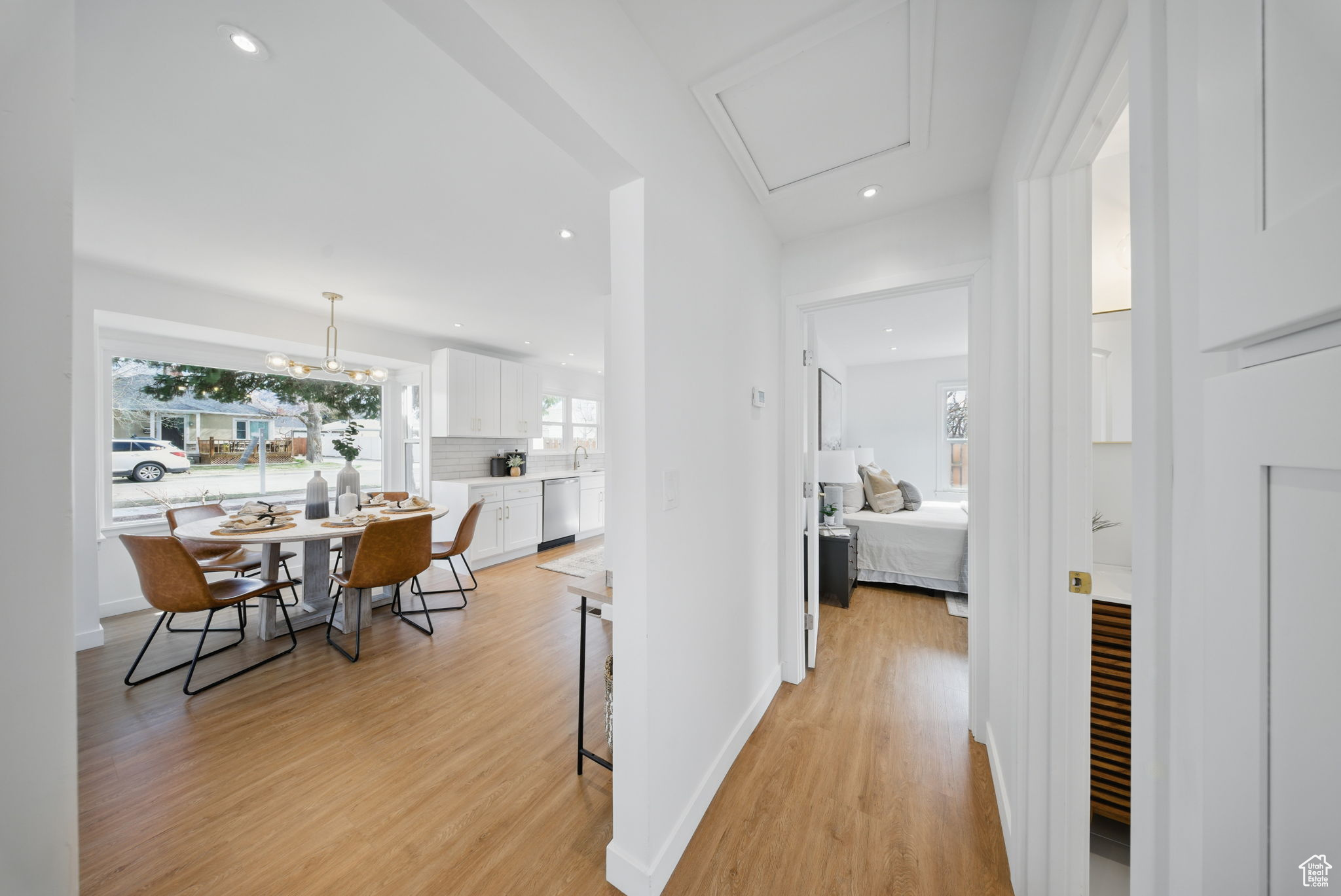 Hall featuring light wood-style flooring, recessed lighting, baseboards, and a sink