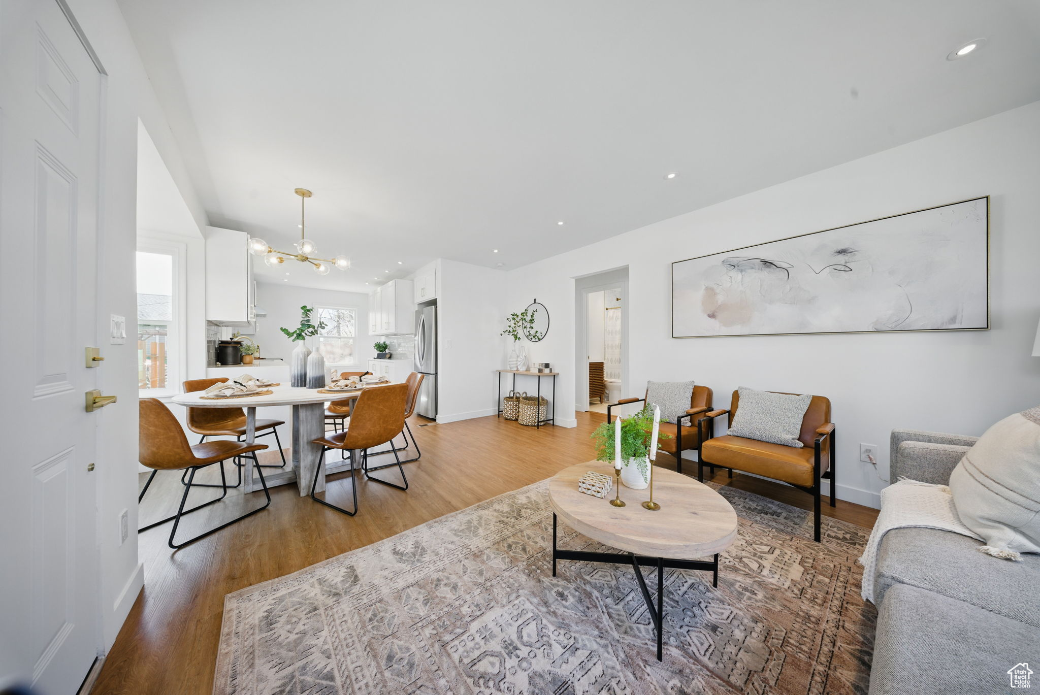 Living area with a chandelier, baseboards, and light wood-style floors