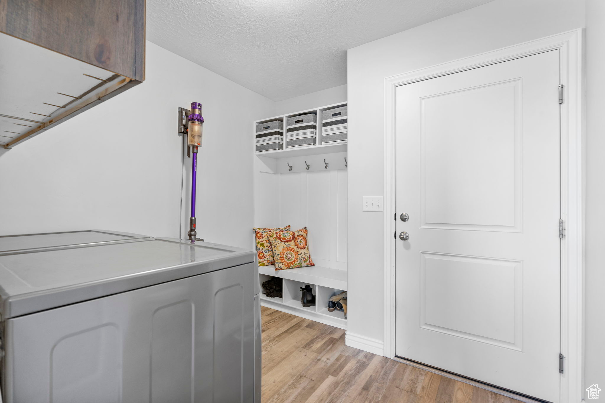 Mudroom featuring a textured ceiling and light wood-style flooring