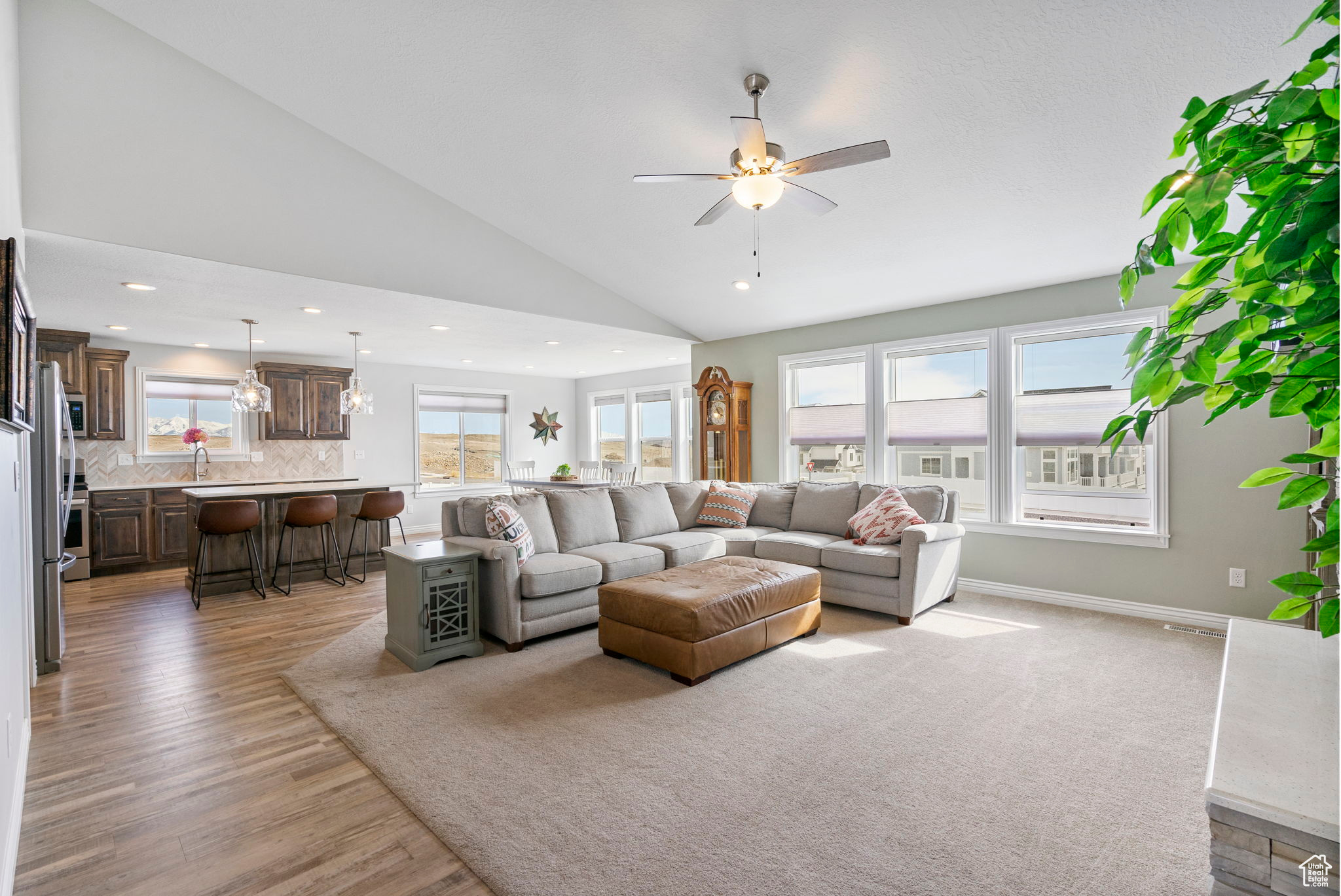 Living area featuring baseboards, high vaulted ceiling, recessed lighting, ceiling fan, and light wood-style floors