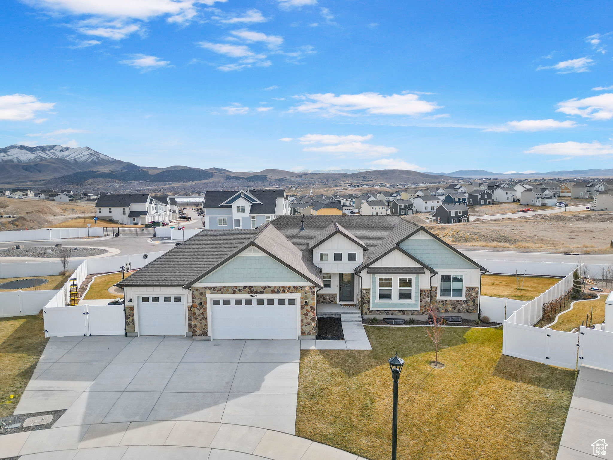 View of front of house featuring a residential view, a front yard, a fenced backyard, an attached garage, and a gate