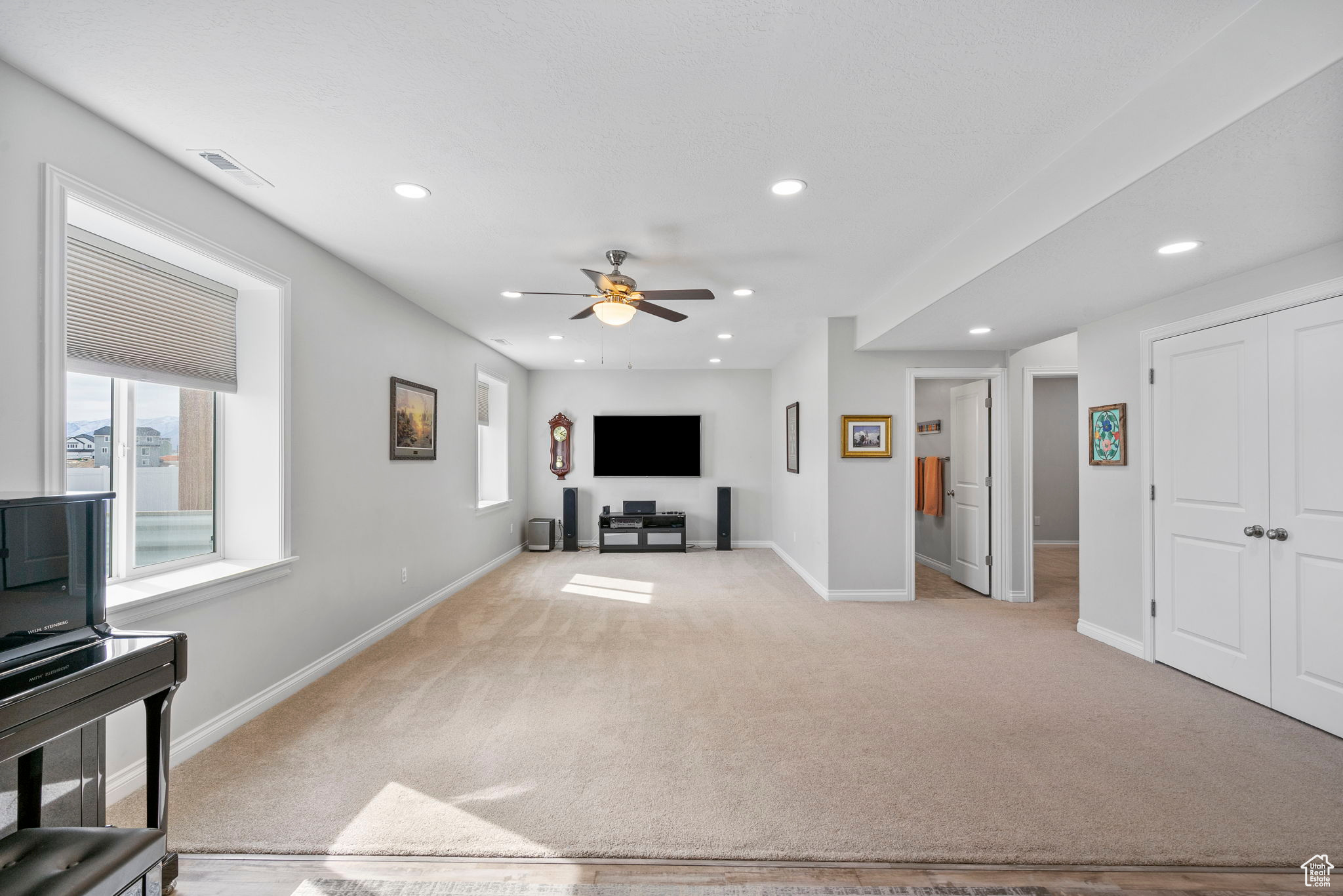 Living area with light carpet, visible vents, and recessed lighting