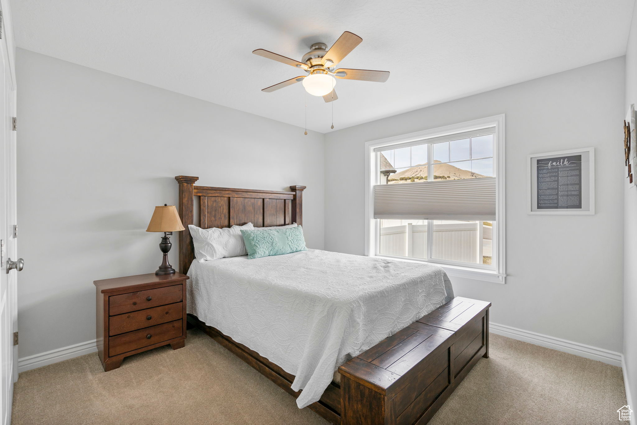 Bedroom with a ceiling fan, baseboards, and light carpet