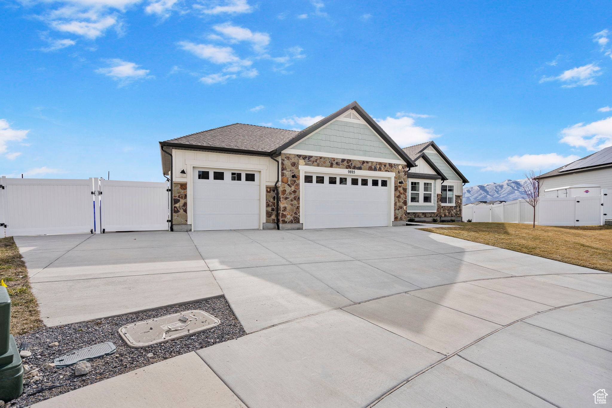 Exterior space featuring a gate, fence, an attached garage, concrete driveway, and a front lawn