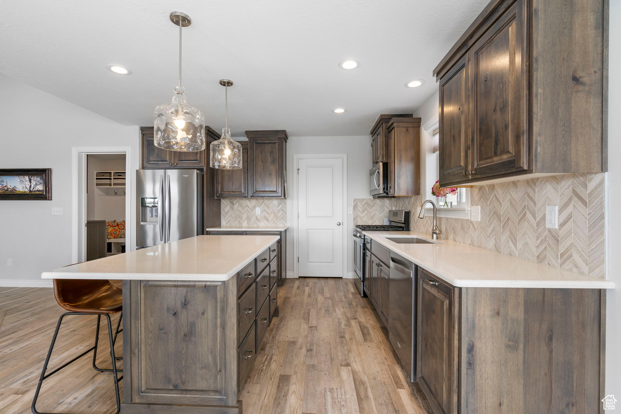 Kitchen featuring dark brown cabinets, appliances with stainless steel finishes, a center island, and a sink