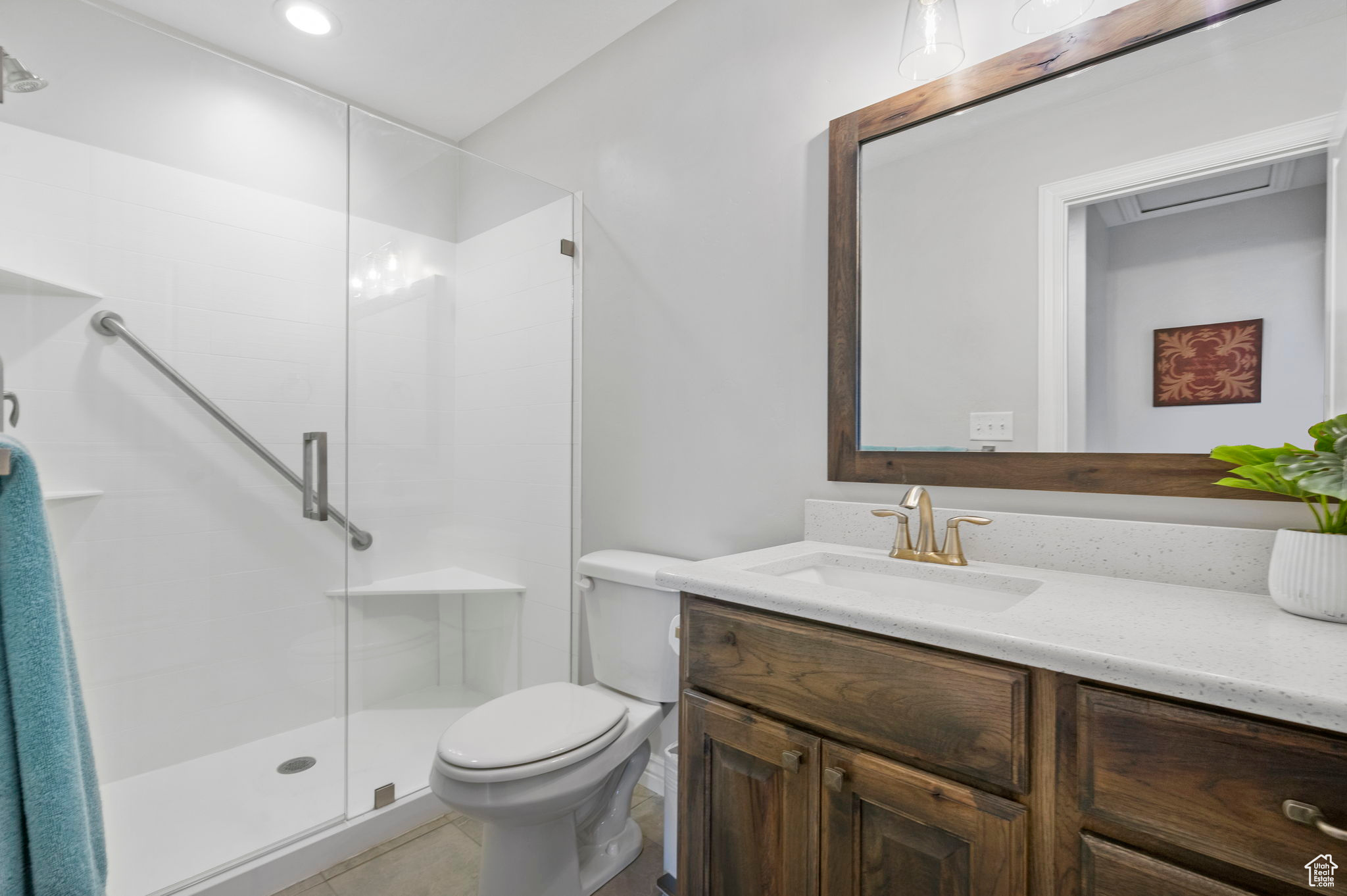 Bathroom featuring vanity, toilet, and a stall shower