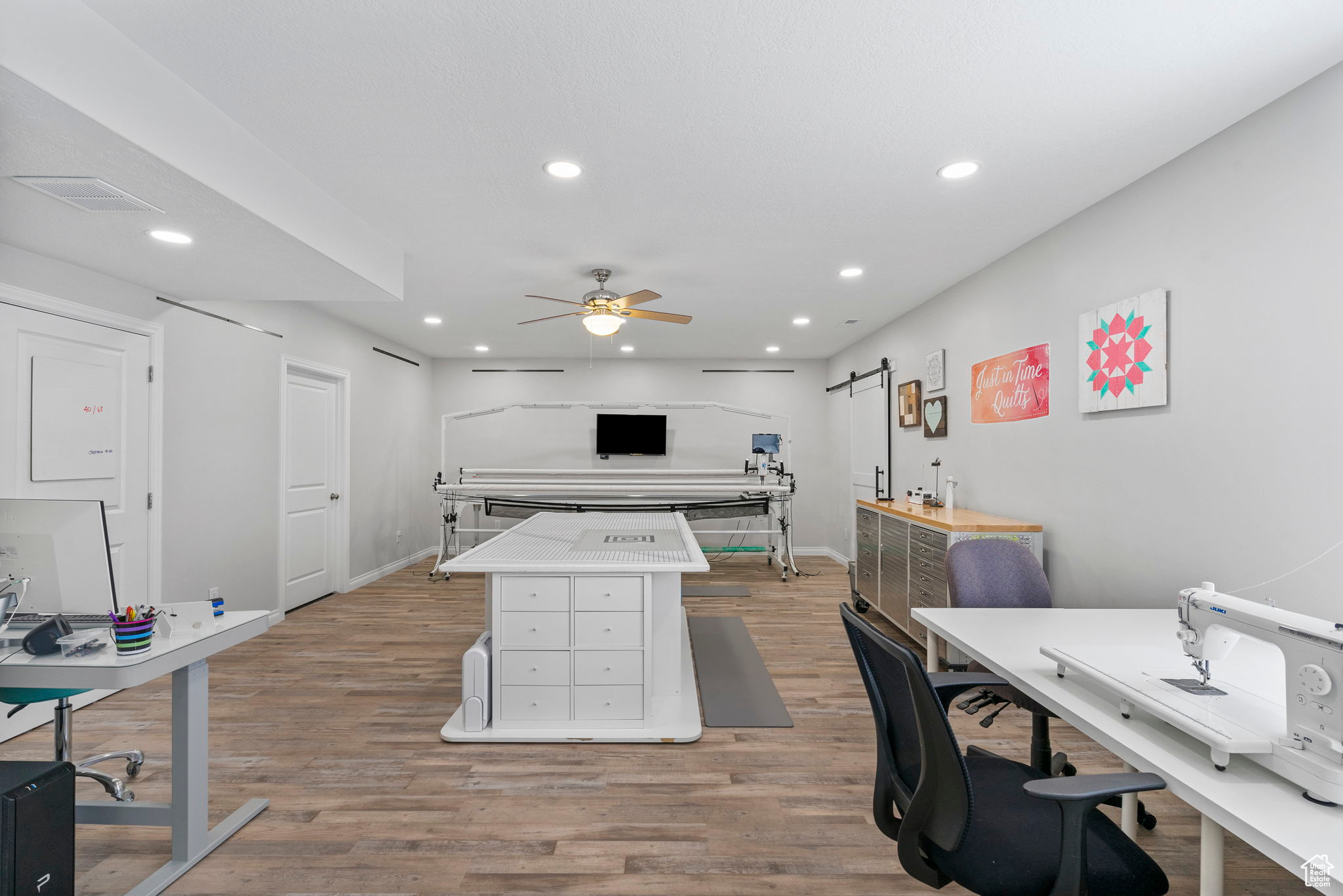 Kitchen with light wood-type flooring, visible vents, recessed lighting, a barn door, and ceiling fan
