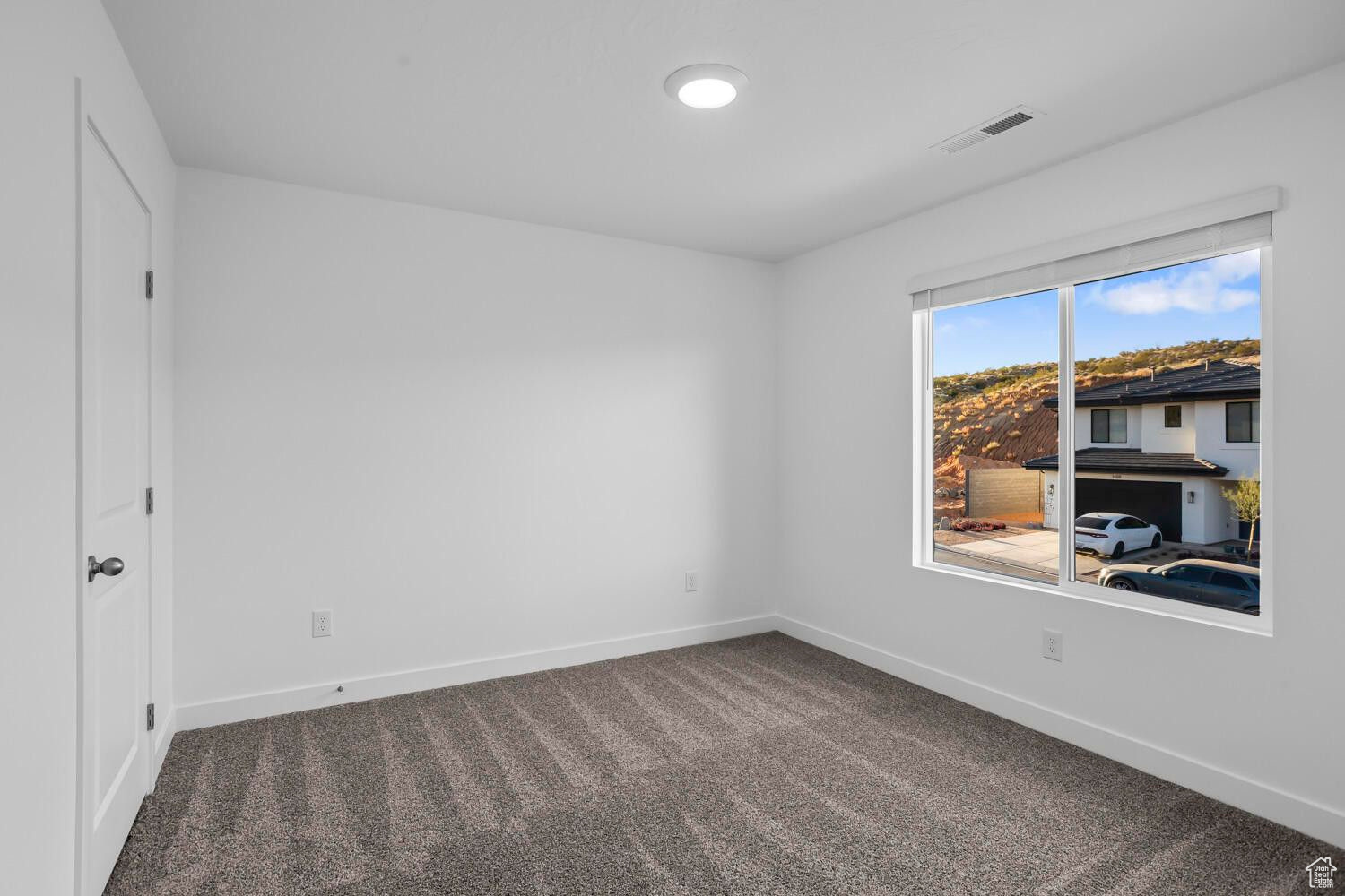 Unfurnished room with carpet flooring, baseboards, and visible vents