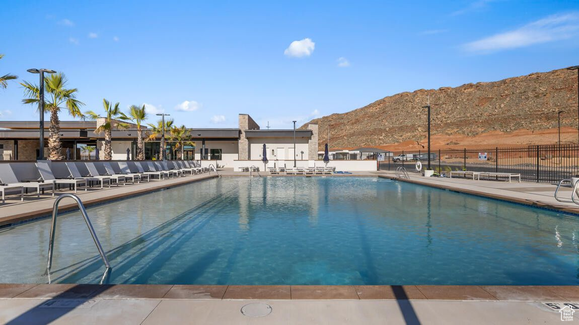 Pool featuring a patio area, fence, and a mountain view