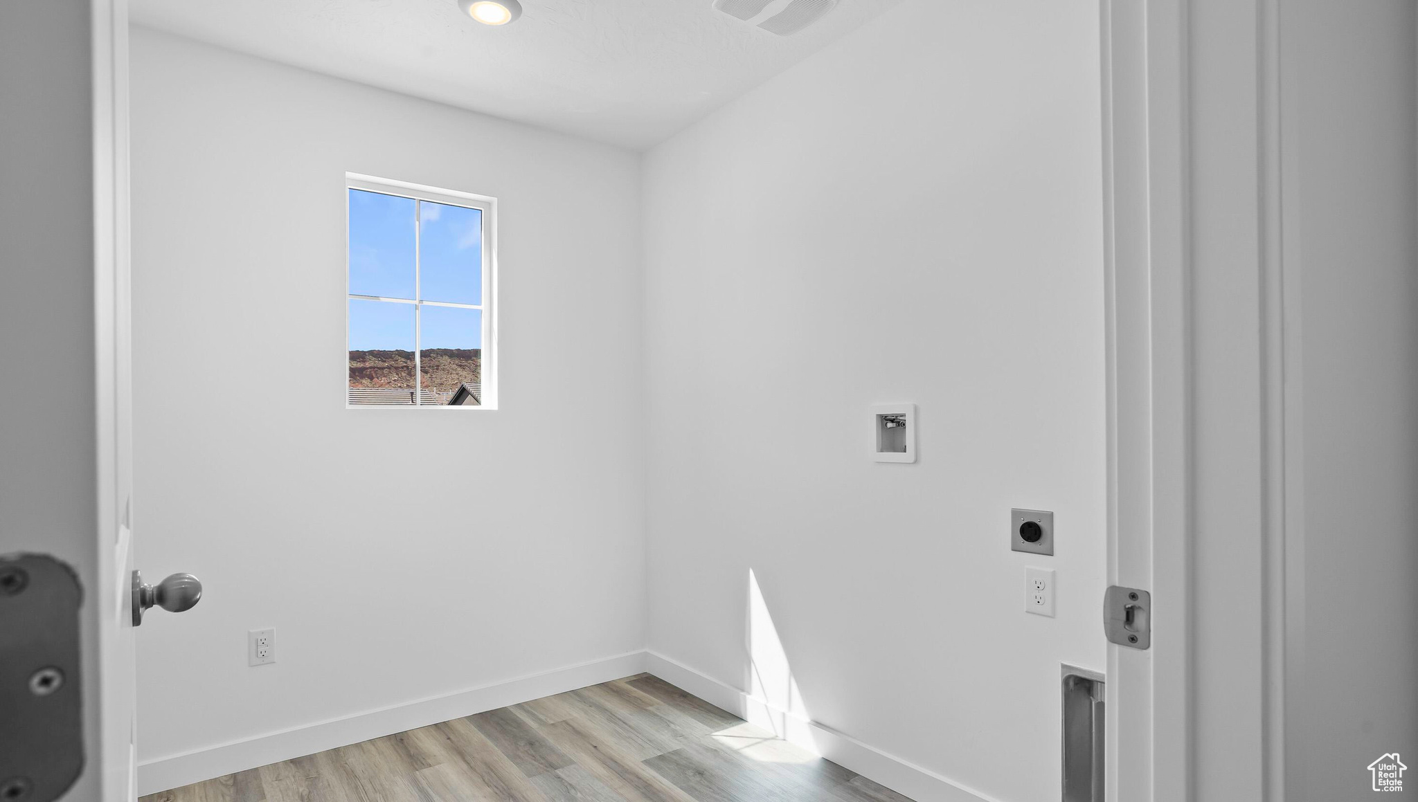 Clothes washing area featuring hookup for a washing machine, baseboards, hookup for an electric dryer, laundry area, and light wood-style flooring