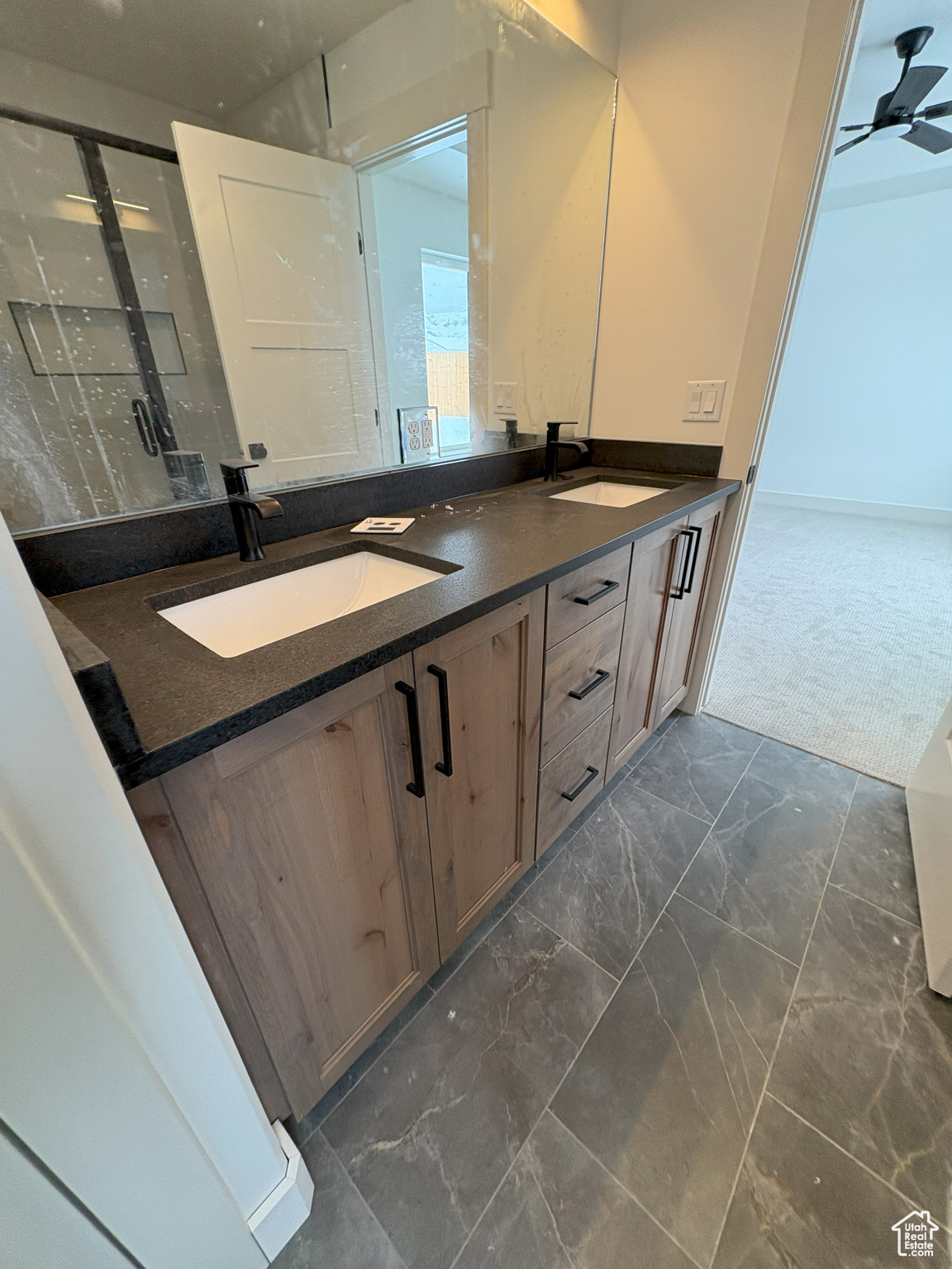 Full bath featuring a sink, marble finish floor, ceiling fan, and double vanity