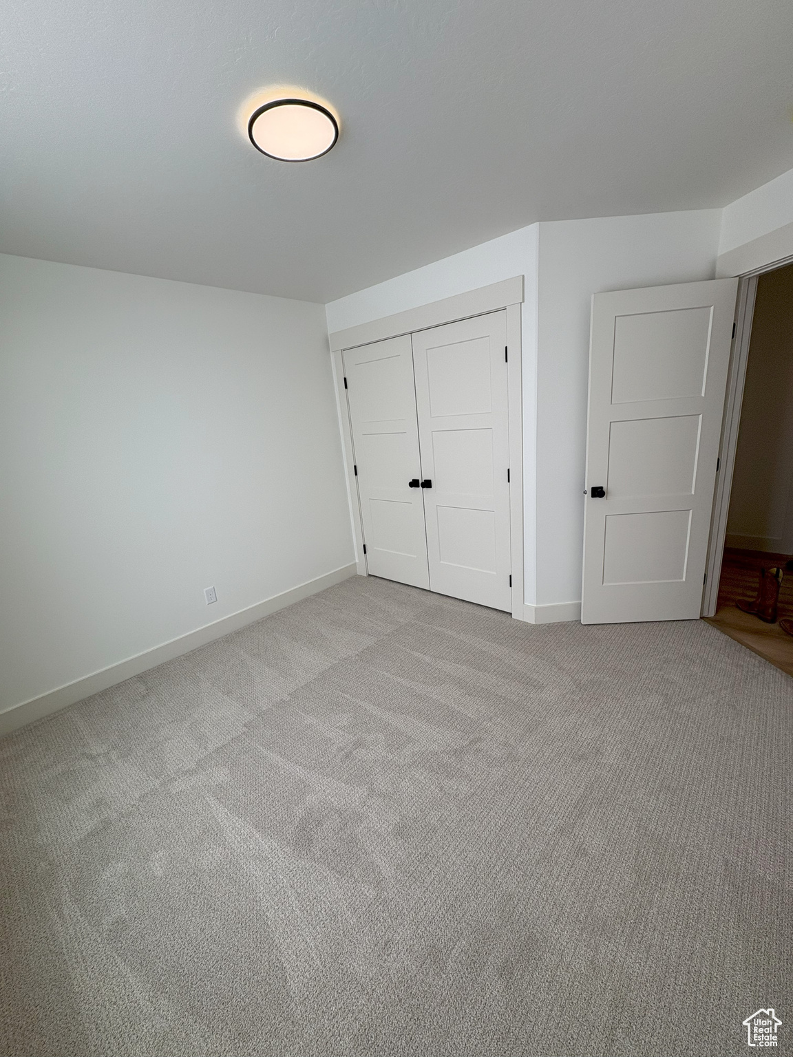 Unfurnished bedroom featuring a closet, baseboards, and carpet