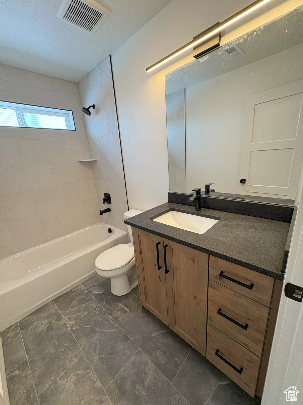 Bathroom with visible vents, toilet, shower / bath combination, marble finish floor, and vanity