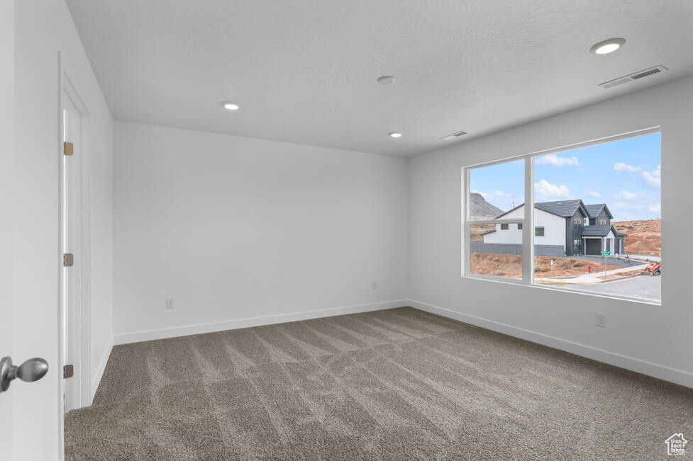 Unfurnished room featuring recessed lighting, visible vents, carpet floors, and baseboards