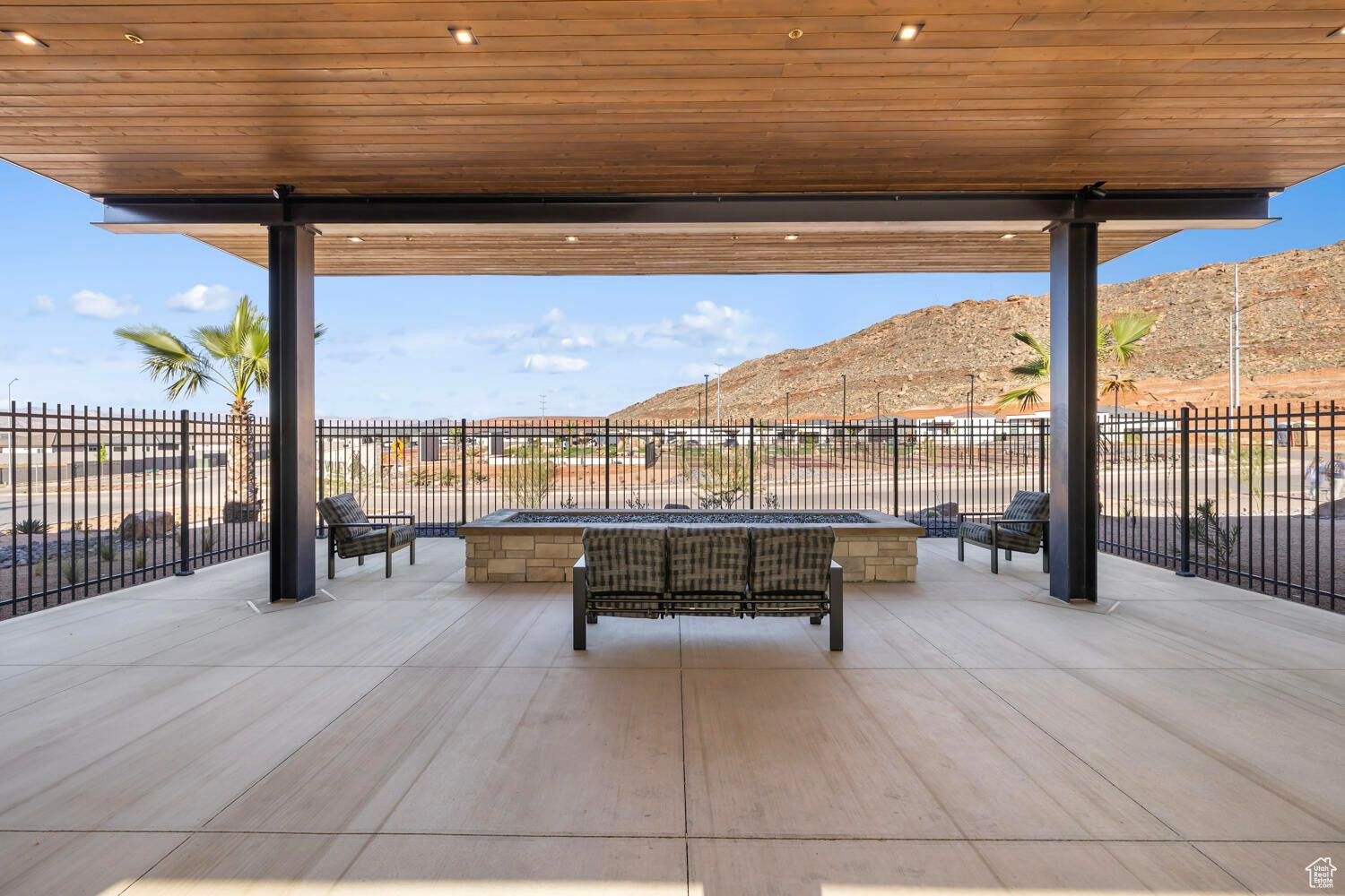 View of patio / terrace with a mountain view, a fenced backyard, and an outdoor fire pit