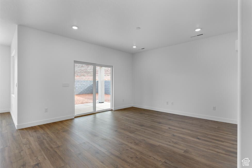 Spare room with recessed lighting, visible vents, baseboards, and dark wood-type flooring