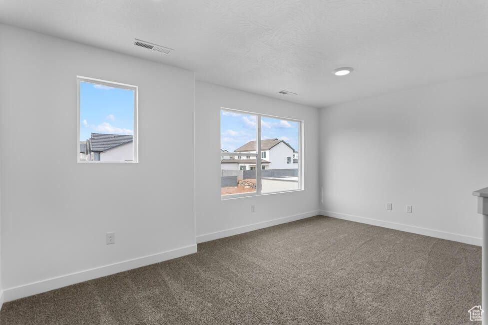 Unfurnished room featuring baseboards, visible vents, and carpet floors