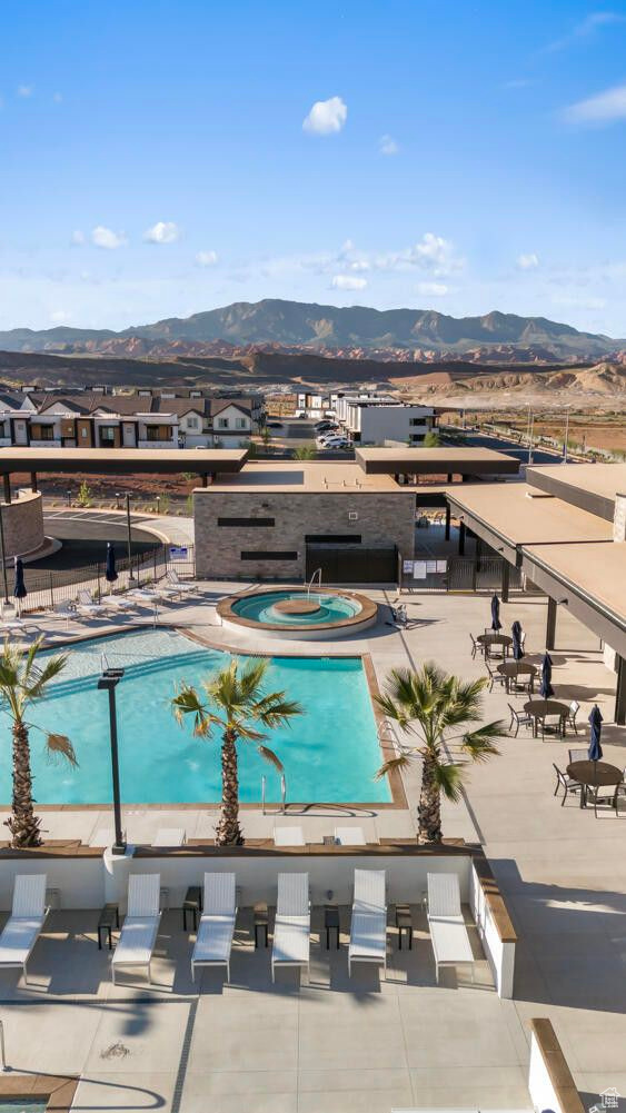 View of swimming pool with a community hot tub and a mountain view