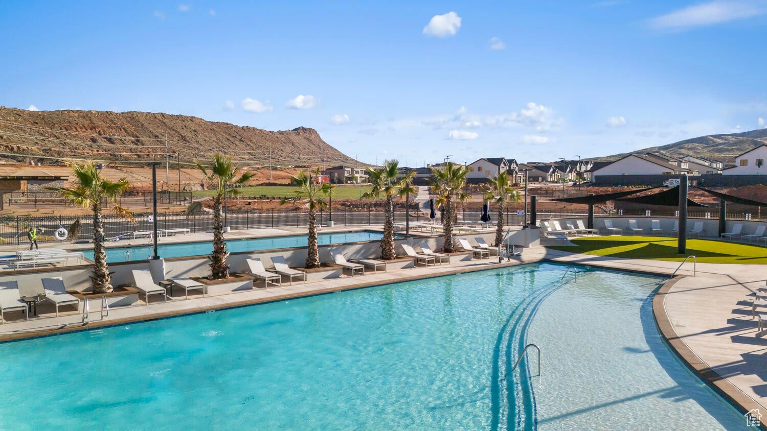 Pool with a mountain view, a patio, and fence