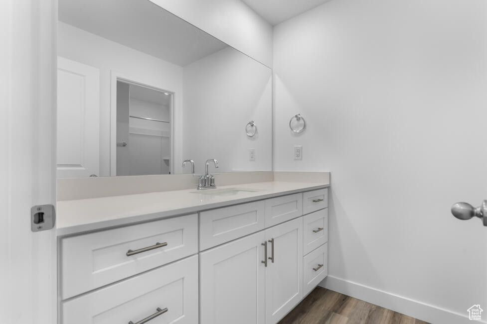 Bathroom featuring vanity, wood finished floors, and baseboards