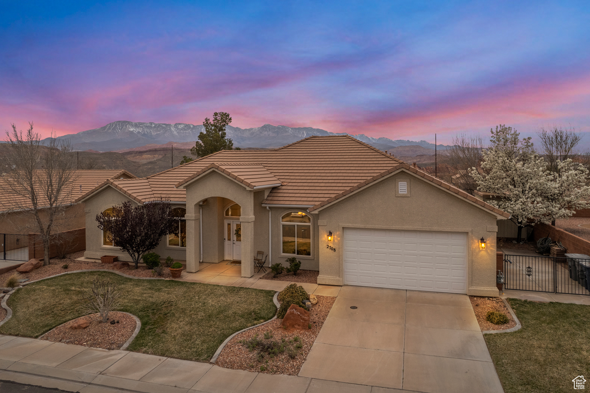 Single story home featuring a mountain view, a garage, stucco siding, and fence