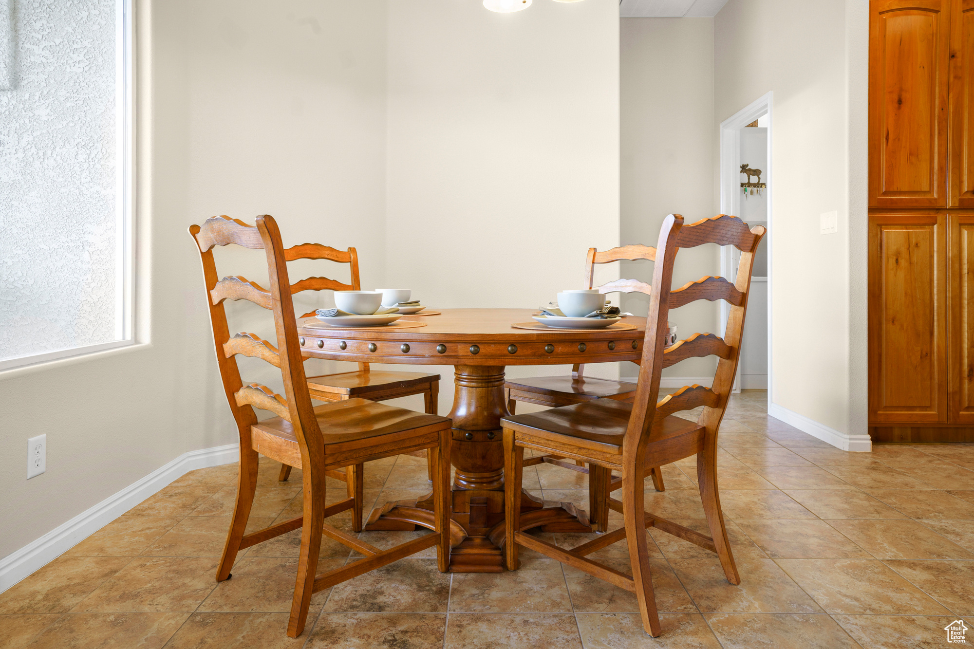 Dining area featuring light tile patterned floors and baseboards