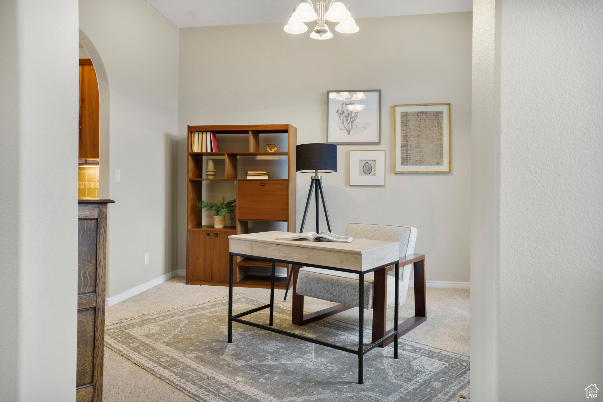 Office with arched walkways, a chandelier, carpet flooring, and baseboards