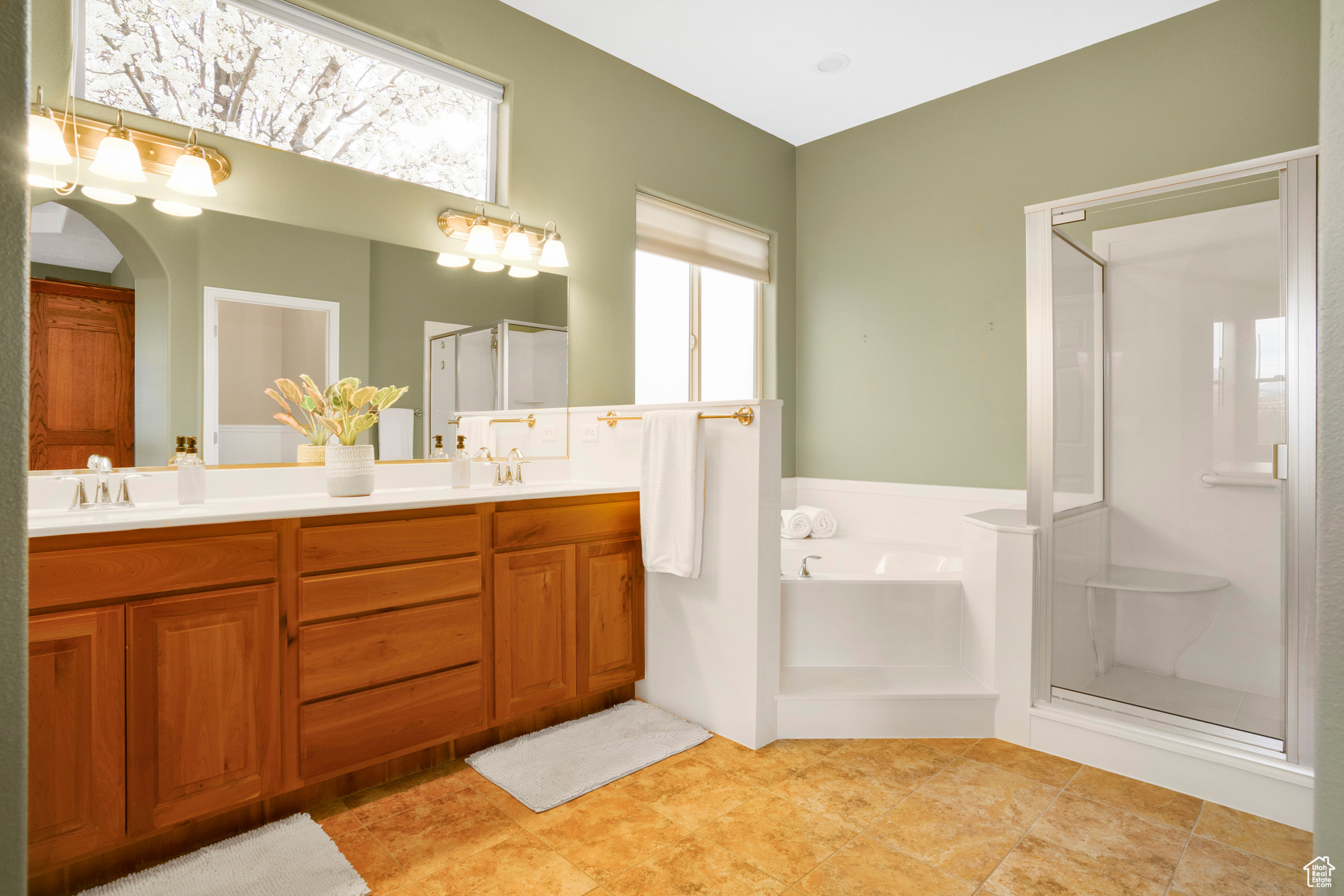 Full bath with a shower stall, a garden tub, double vanity, and a sink