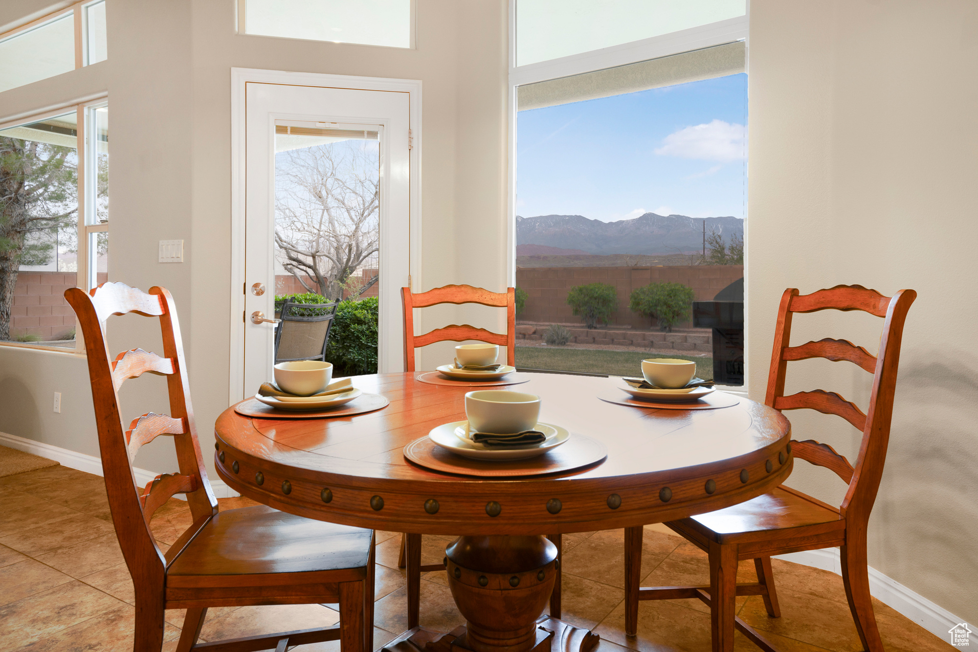 Dining area featuring light tile patterned floors, a mountain view, and baseboards