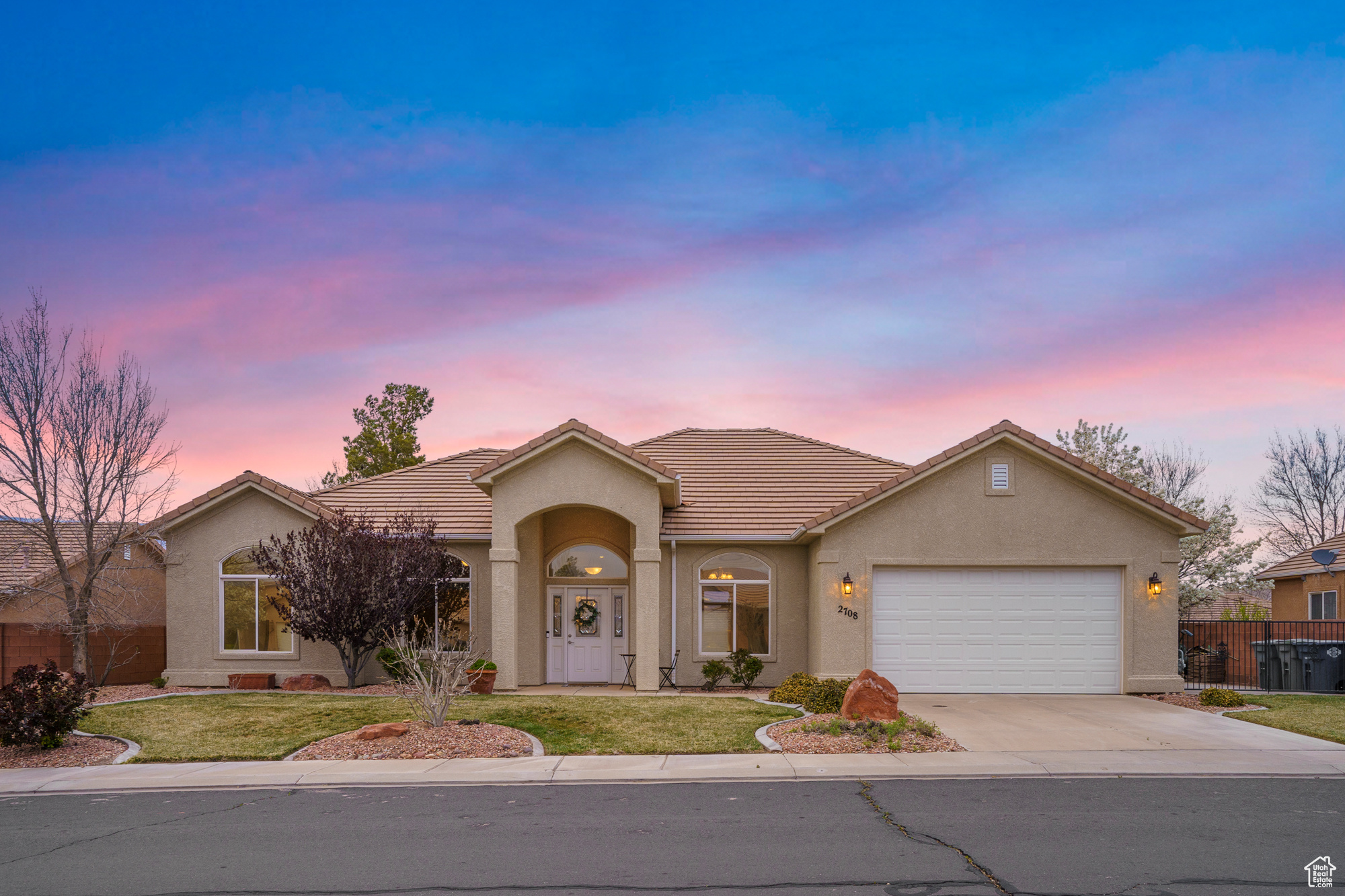 Single story home featuring fence, concrete driveway, stucco siding, a lawn, and an attached garage