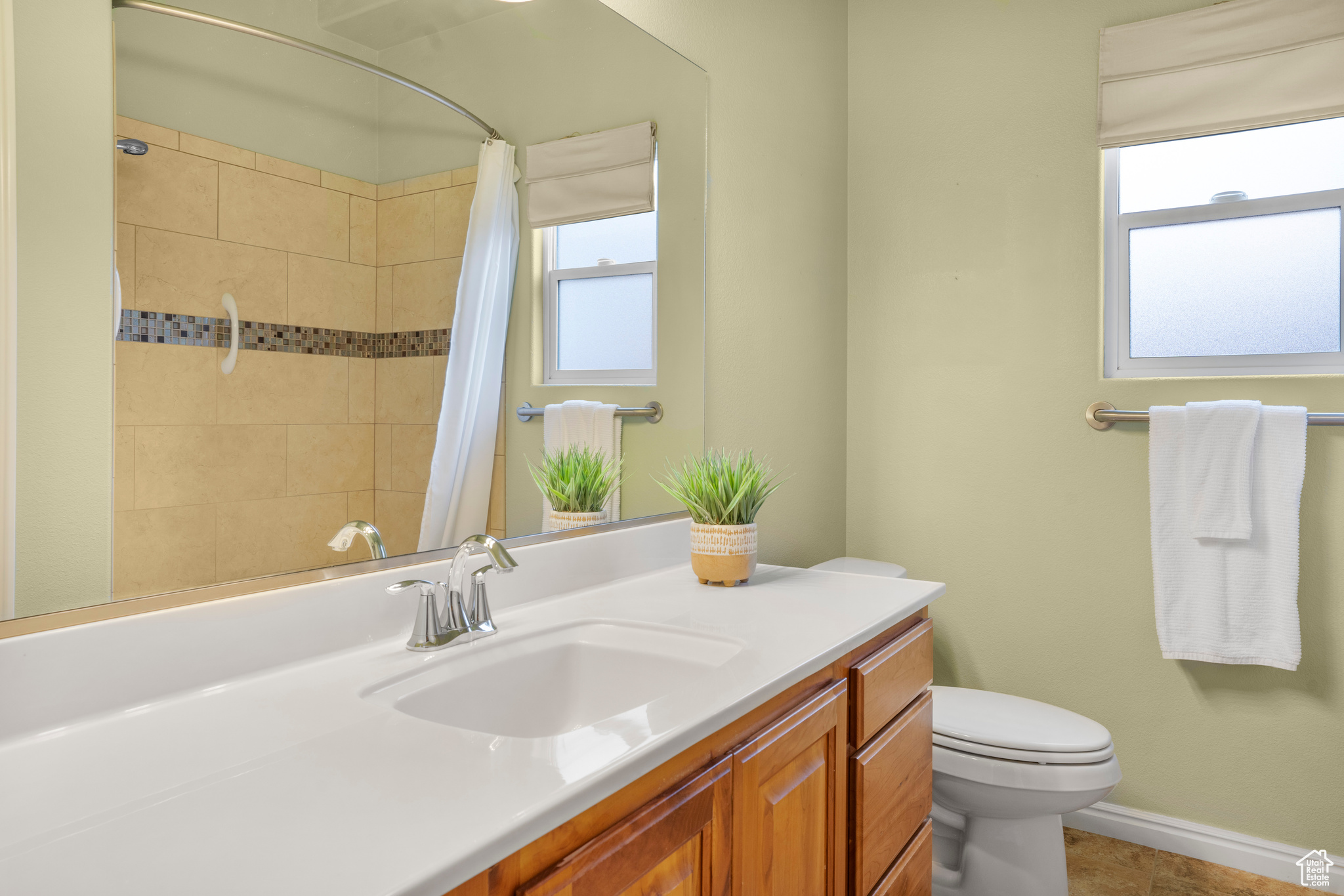 Bathroom with vanity, toilet, a shower with curtain, and baseboards