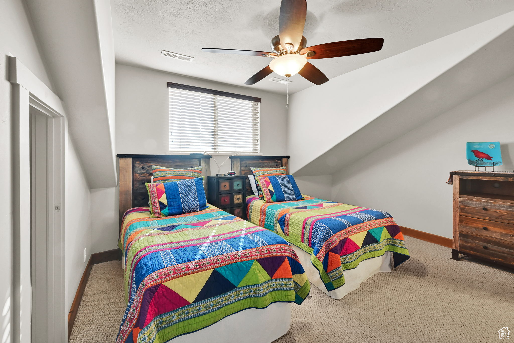 Carpeted bedroom featuring visible vents, a textured ceiling, baseboards, and a ceiling fan